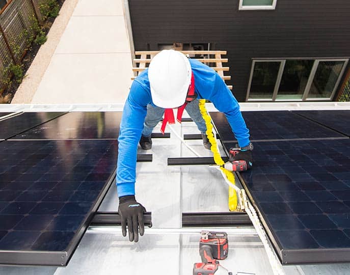 Solar panel installer scaling a roof
